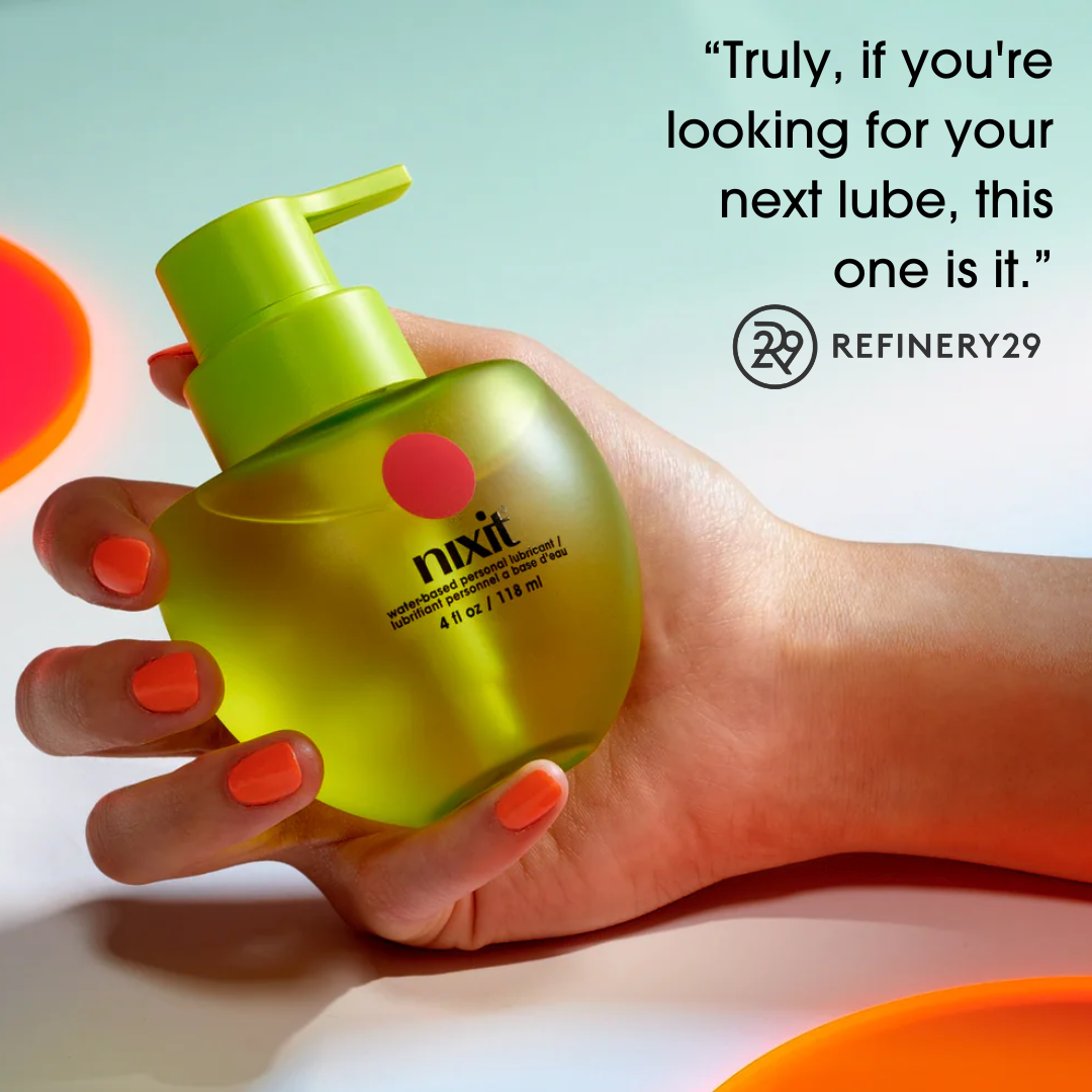Hand holding a green nixit water based personal lubricant with vibrant orange and pink accents against a colorful background.