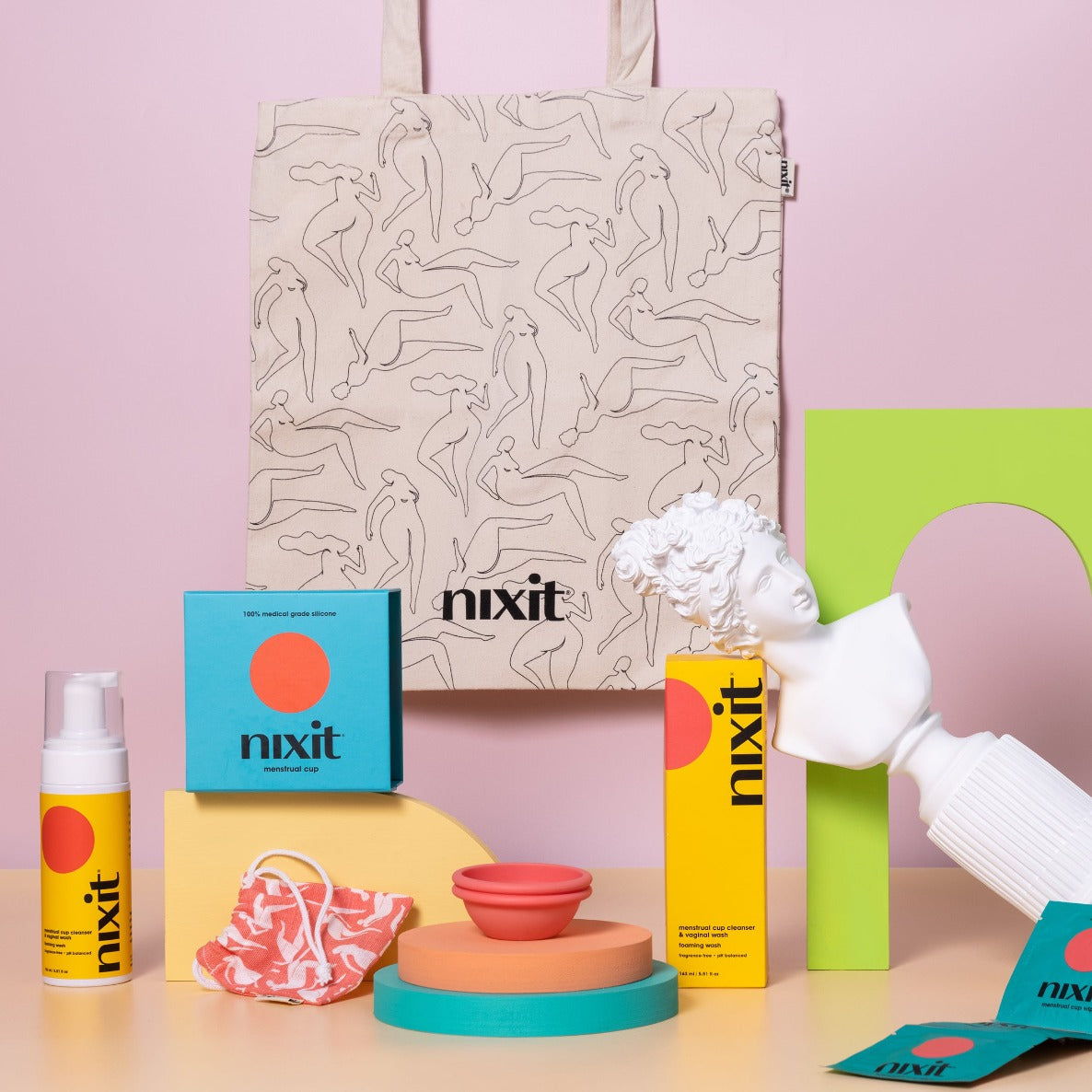 An image of an array of nixit products in the foreground (wash, menstrual cup and wipes) with the nixit tote hanging in the background