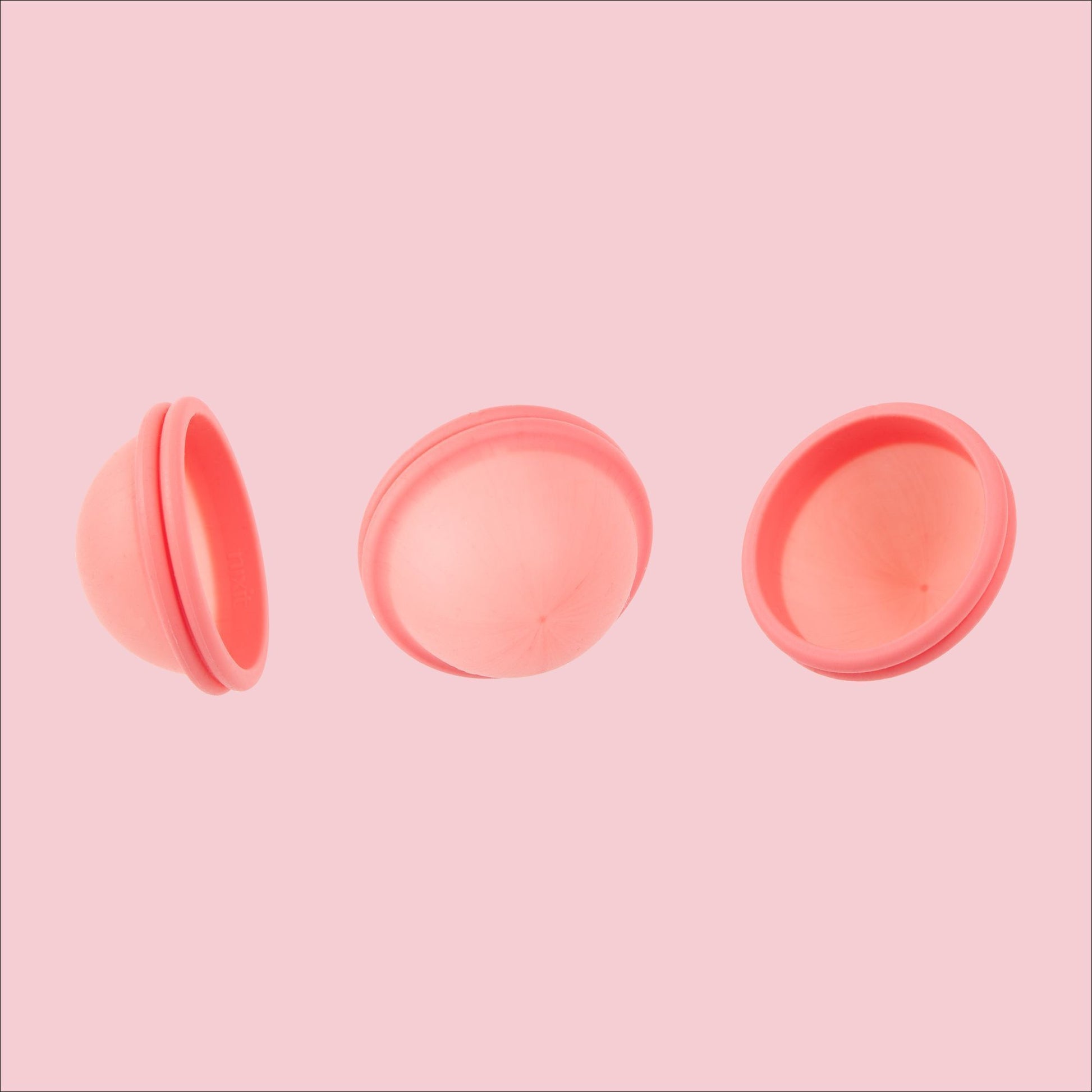Front, back, and side image of nixit menstrual cup showing the disc shape at all angles